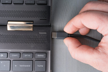 USB Type C grey cable being connected to the laptop computer. Flat lay top view.の写真素材