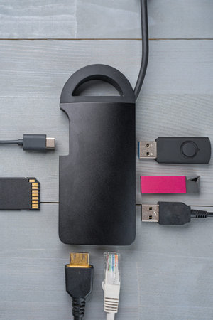 USB Type C adapter or hub with various accessories - pendrives, hdmi,  memory card, cables. Flat lay top view. Vertical orientation.の写真素材