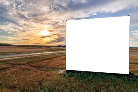 Aerial drone shot of big blank billboard near busy highway or motorway at sunsetの写真素材