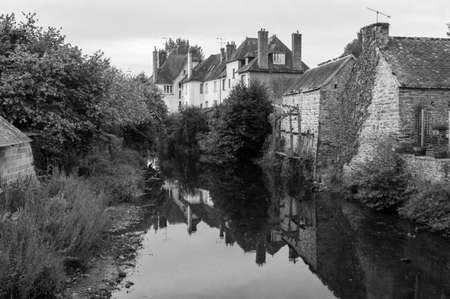 Black and white photographic scene of river running through a small French villageのeditorial素材