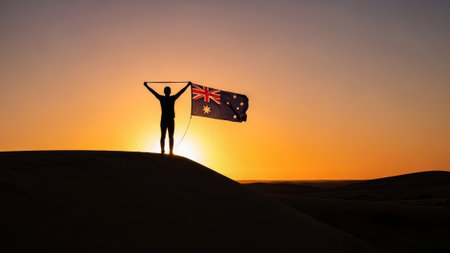 Man with Australian flag on desert dune at sunsetの素材
