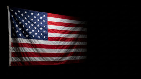 US flag waves in dark, dramatic lighting.の素材