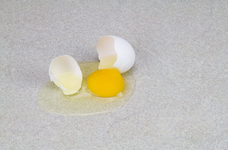 A broken egg on a counter top 