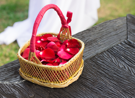 Red rose petals in bamboo basketの写真素材