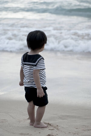 Little boy in sailor's uniform on beachの写真素材