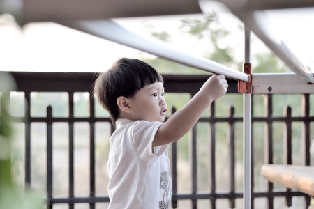 Young boy playing clotheshorseの写真素材