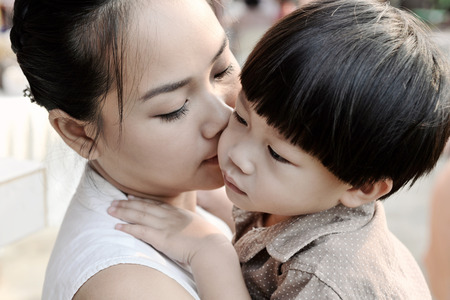 Closeup young mother kissing her sonの写真素材