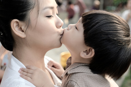 Closeup mother and son kissing togetherの写真素材