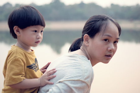 Young boy on back of his mother : Soft foucusの写真素材