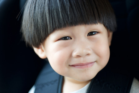 Closeup happy little boy sitting in the carの写真素材