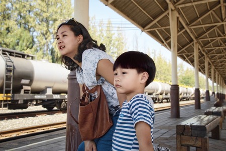Young mother and son waiting for trainの写真素材