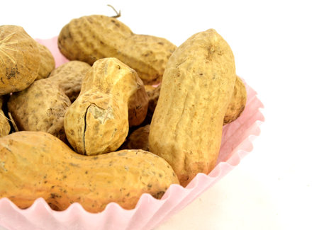 Peanuts in the shell in a pink paper cup 