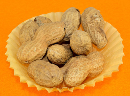 Peanuts in the shell in a yellow paper cup.