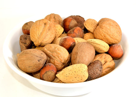 Walnuts, Brazil nuts, Almonds, Hazelnuts and pecans in a white dish.