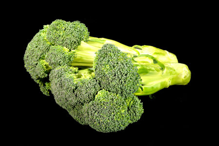 Bunch of broccoli on a black background.