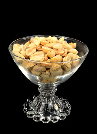 Peanuts in a glass bowl on a black background.の写真素材