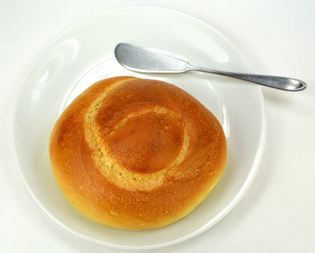 Egg twist roll on a white plate on a white background.