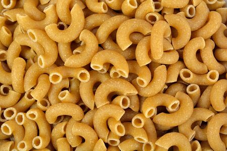 Close-up of whole wheat elbow pasta as a background.の写真素材