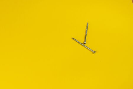 steel screws against a colored background. screws on a yellow background. space for the inscription. space for the site and sale.の写真素材