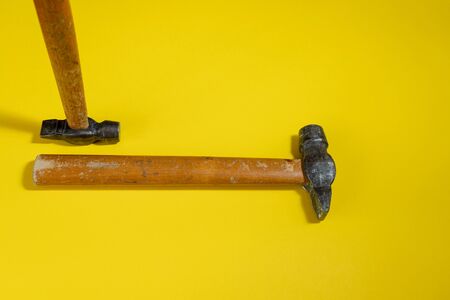hammers against a colored background. a tool for housework. working a necessary tool. a regular hammer for hammering nails.の写真素材