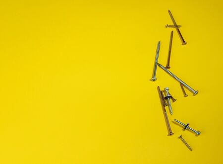 steel screws against a colored background. screws on a yellow background. space for the inscription. space for the site and sale.の写真素材