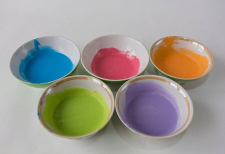 five deep bowls of paint on a white background. pastel blue, pink, green, purpleの写真素材