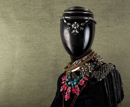 A necklace made by hand in an unusual way is presented of a portrait mannequin woman. On a light green background, the necklace glitters. Reflections. Not precious stones or metalの写真素材