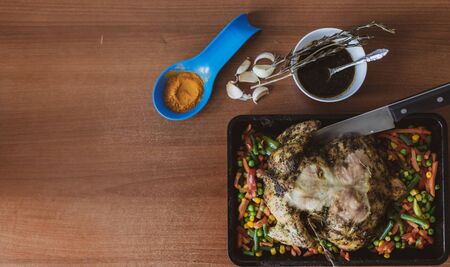 whole chicken in the oven. chicken with baked crispy crust lies on a baking wall. next to them are baked vegetables - carrots, beans, peas. juicy vegetables and cooked birdの写真素材