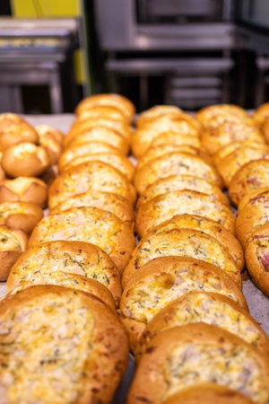 A lot of buns with different fillings and toppings are on the counter.