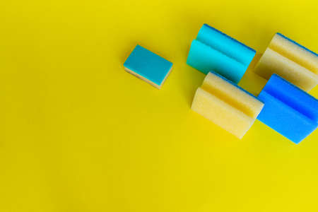 Dish washing sponges of different colors are on a yellow background. High quality photoの写真素材