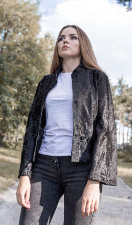 a beautiful girl with long hair and expressive eyes poses in a fur coat in a Park. High quality photoの写真素材