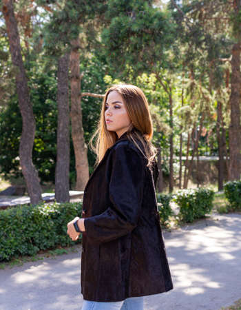 a beautiful girl with long hair and expressive eyes poses in a fur coat in a Park. High quality photoの写真素材