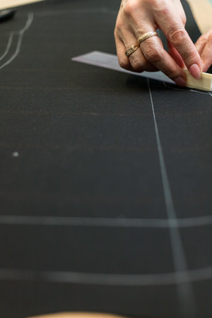 The dressmaker will open the fabric for the future costume for further work. Fashion designer tailor...