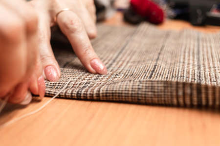 The dressmaker will open the fabric for the future costume for further work. Fashion designer tailor in the workshop of the studio, developing a new collection of clothes.の写真素材