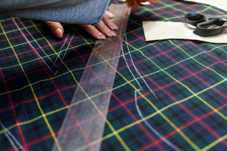 The dressmaker will open the fabric for the future costume for further work. Fashion designer tailor...