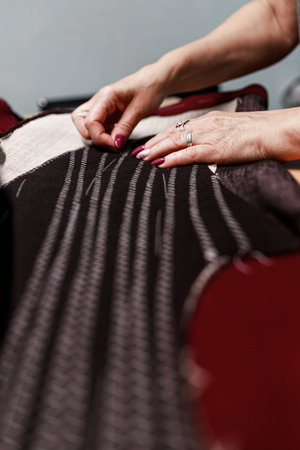 womens hands with scissors create a composition together with fabric, atelier