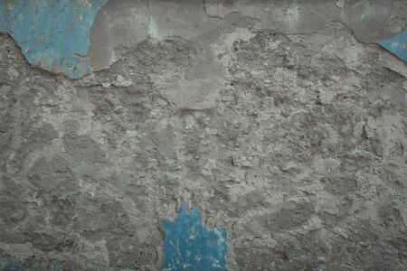 Old gray stone wall with blue paint texture background. Cracked aged dark surfaceの写真素材
