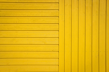 Yellow wooden texture background. Wall surface. Horizontal and vertical wooden boards. Close up with copy spaceの写真素材