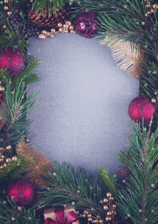 Creative layout made of fir branches and decorations with blank gray card of eco recycled paper. Toned Christmas or New Year background with copy space for text. Top view. Holidays conceptの写真素材
