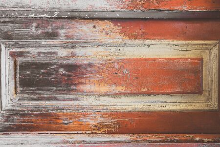 Multicolor old wooden texture background. Scratched weathered wooden door detail with peeled off paint. Horizontal brown, red, yellow, black and orange wood surface. Copy spaceの写真素材