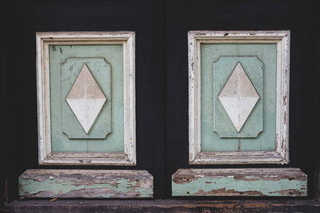Old vintage wooden door detail. Geometric wooden decoration with dirt and peeled off paint. Dark...