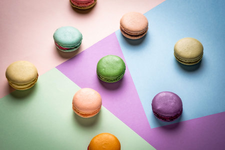 Colorful macaroons on creative geometric pastel background. Variety of french almond macaron cookies...