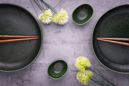Empty plates for sushi on gray background. Plates, soy sauce bowl and chopsticks. Oriental table set up. Asian restaurant menu. Copy space, top viewの写真素材