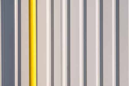 White and yellow metal wall texture background. Modern building wall from metal plates with yellow...