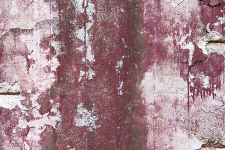 Abstract grunge texture of old red wall with peeled off paint. Creative background. Pink, gray, red, white and brown beautiful rough weathered stone texture. Copy spaceの写真素材