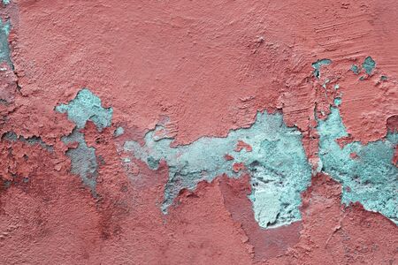 Abstract grunge texture of old colorful block wall with grain and scratches. Blue wall with peeled off pink paint. Creative background. Beautiful rough weathered stone texture. Copy spaceの写真素材