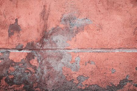 Abstract grunge texture of old colorful block wall with grain and scratches. Creative background. Pink, red, peachy and gray beautiful rough weathered stone texture. Copy spaceの写真素材