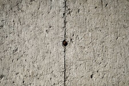 Abstract, grunge, old cement stone wall texture background. Rough weathered wall blocks with nail. Close up, copy spaceの写真素材