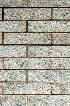 Gray brick wall texture background. Modern construction. Beautiful new bricks made of stones. Vertical, Close upの写真素材