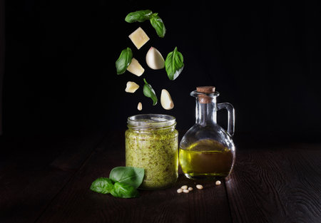 pesto sauce in a glass jar with flying ingredients.の写真素材